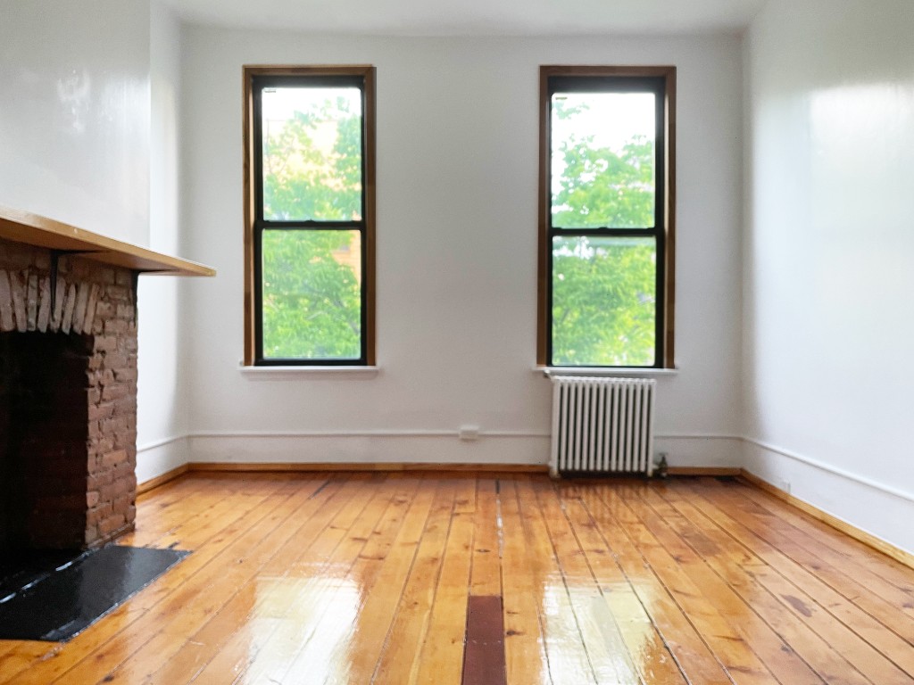 an empty room with a fireplace and a window
