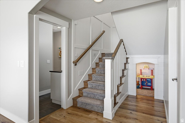 21 Pier Place Tooele, UT 84074 - Photo 46 of 112 Light wood-finish flooring with a carpeted staircase featuring white risers and a wood handrail