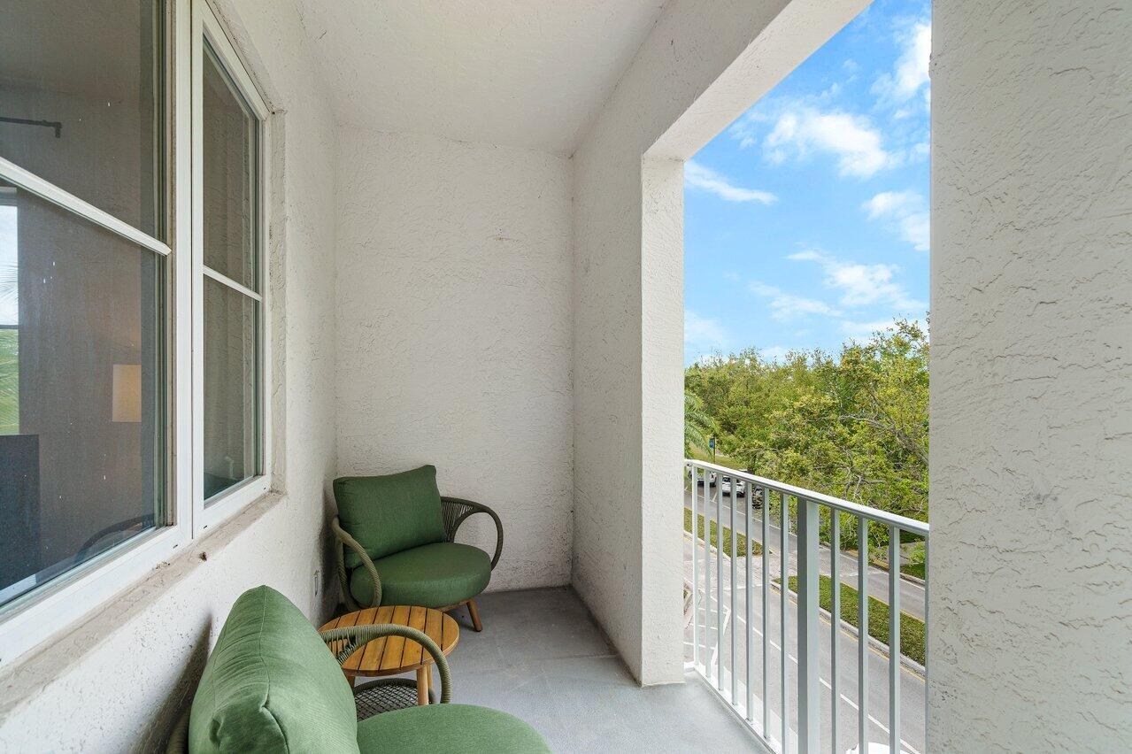 1209 Main Street, Unit 302 Jupiter, FL 33458 - Photo 16 of 20 a balcony with chairs and a potted plant