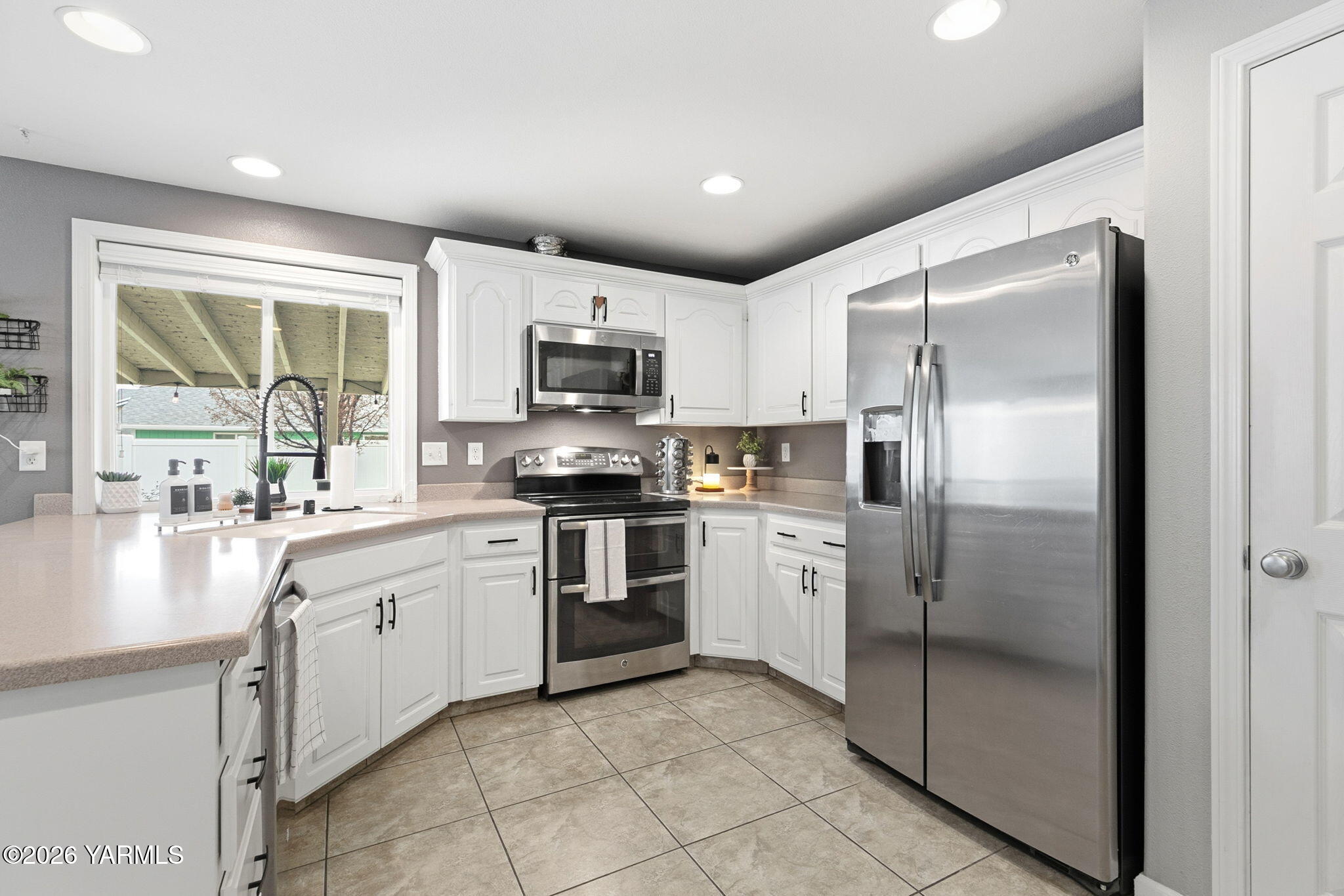 204 Clemans Avenue Moxee, WA 98936 - Photo 11 of 29 a kitchen with white cabinets stainless steel appliances and a window