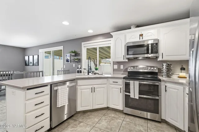 a kitchen with granite countertop a stove top oven sink and microwave