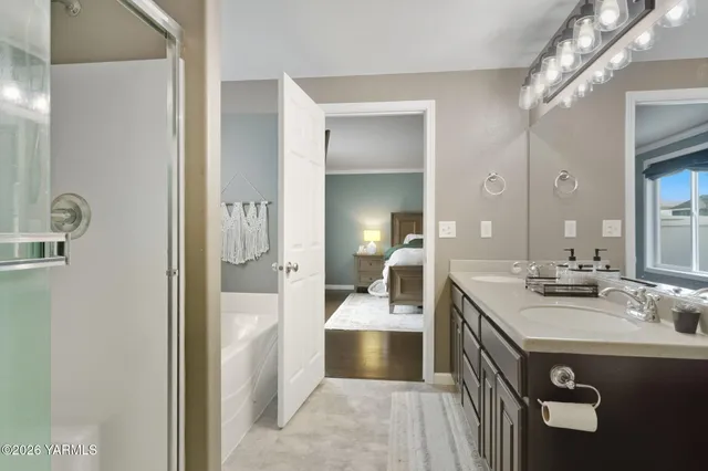 a en suite bathroom with a sink double vanity and a mirror