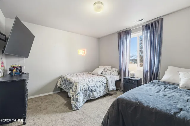 a bedroom with two beds and a flat screen tv