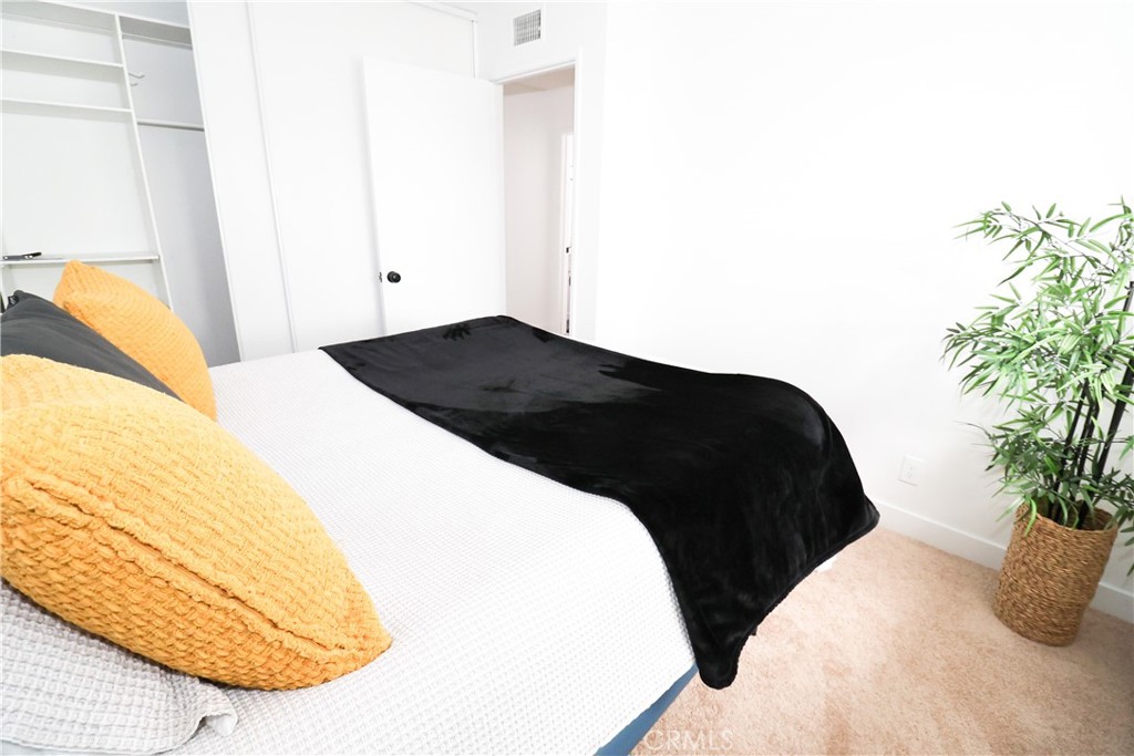1161 Blue Ridge Lane Colton, CA 92324 - Photo 20 of 36 a bedroom with a bed and a potted plant