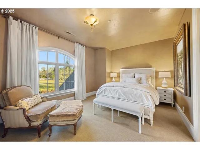 a bedroom with a bed and a large window