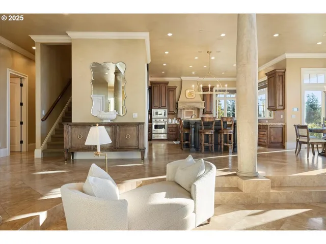 a living room with couches and kitchen view with wooden floor