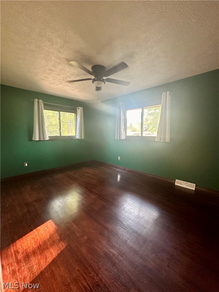 5855 Liberty Road Solon, OH 44139 - Photo 12 of 19 Unfurnished room with a textured ceiling, a wealth of natural light, hardwood / wood-style flooring, and ceiling fan