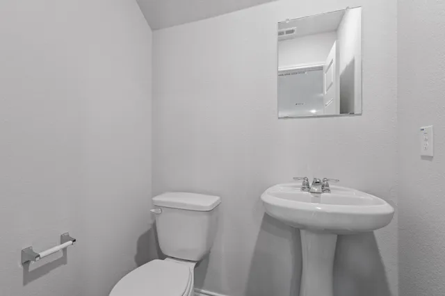 a bathroom with a sink mirror and toilet