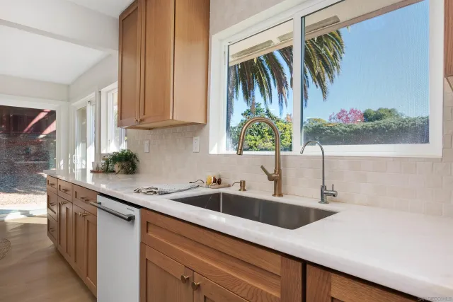 a kitchen with stainless steel appliances a sink a stove and a window