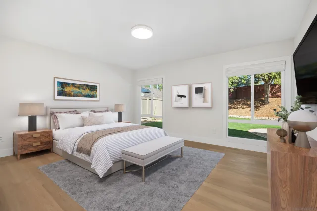 a spacious bedroom with a bed and a flat screen tv