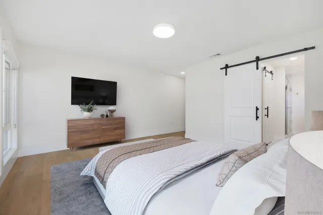 a bedroom with a bed tv and a window