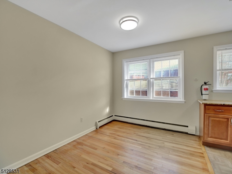 153 Ridge Road, Unit D Cedar Grove, NJ 07009 - Photo 12 of 21 an empty room with wooden floor and windows