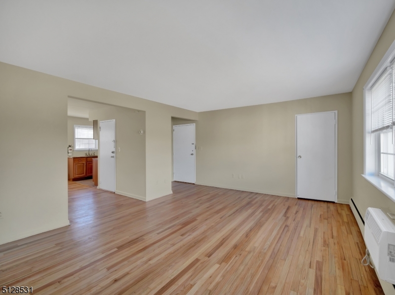 153 Ridge Road, Unit D Cedar Grove, NJ 07009 - Photo 5 of 21 an empty room with wooden floor and windows