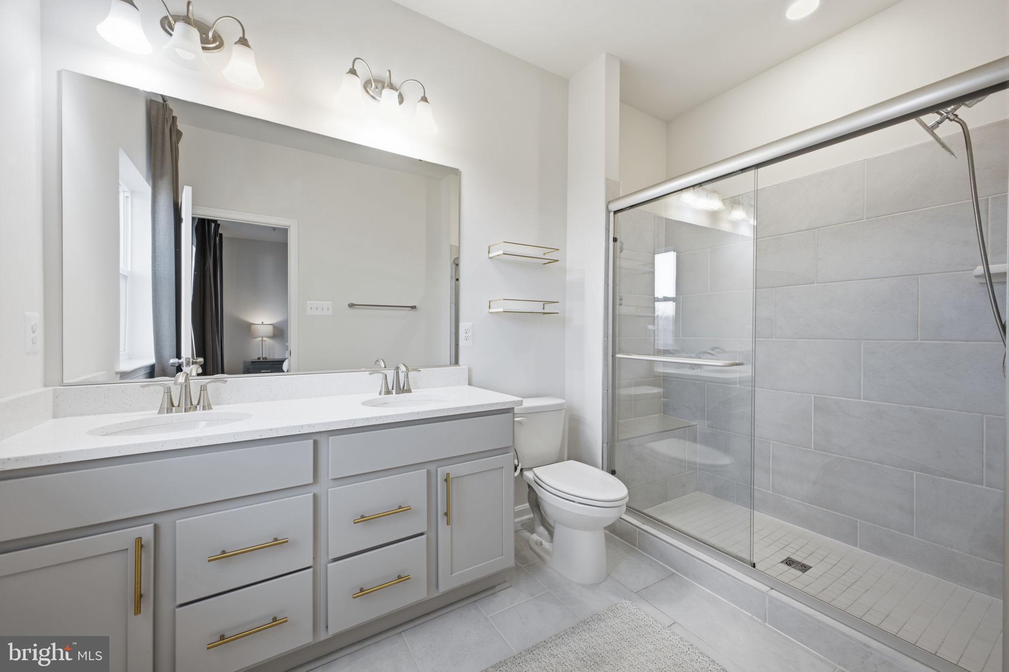217 Southwind Drive Accokeek, MD 20607 - Photo 27 of 34 a bathroom with a double vanity sink toilet and shower