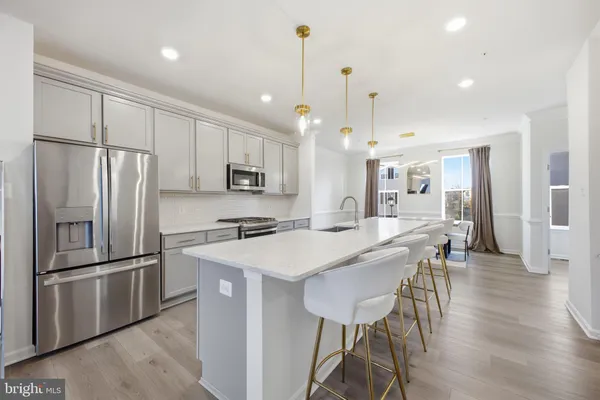 a kitchen with stainless steel appliances granite countertop a sink a stove and a wooden floors