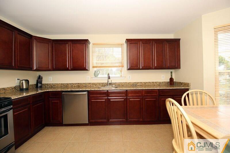 44 Cannon Road Old Bridge, NJ 08857 - Photo 5 of 24 a kitchen with granite countertop wooden cabinets a sink a window and stainless steel appliances