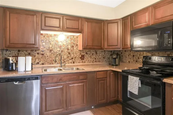 a kitchen with stainless steel appliances granite countertop a sink stove and cabinets