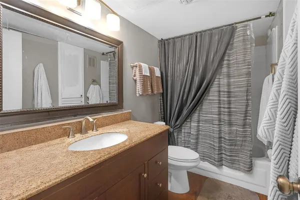 a bathroom with a granite countertop sink toilet and shower