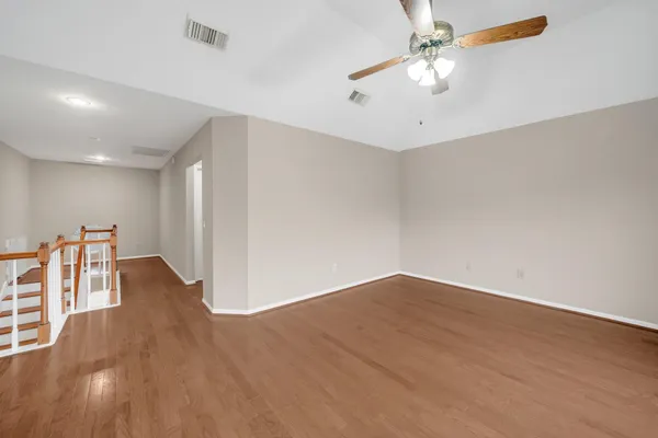 a view of a hallway with wooden floor and staircase