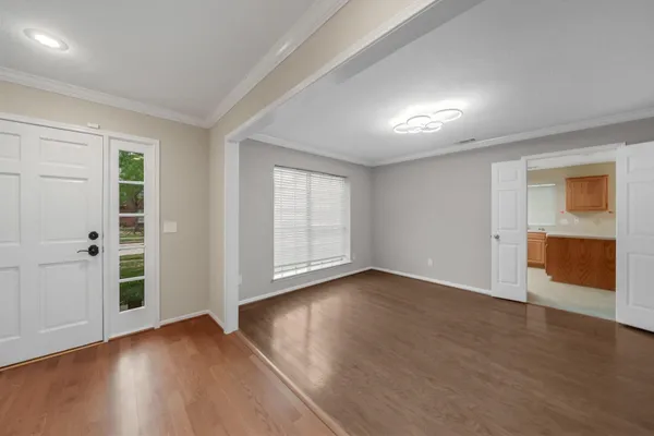 an empty room with wooden floor and windows