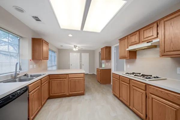a large kitchen with stainless steel appliances granite countertop a sink stove and cabinets