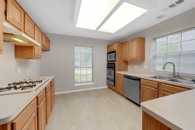 a kitchen with stainless steel appliances granite countertop a sink stove and cabinets