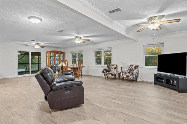 a living room with furniture ceiling fan and a window