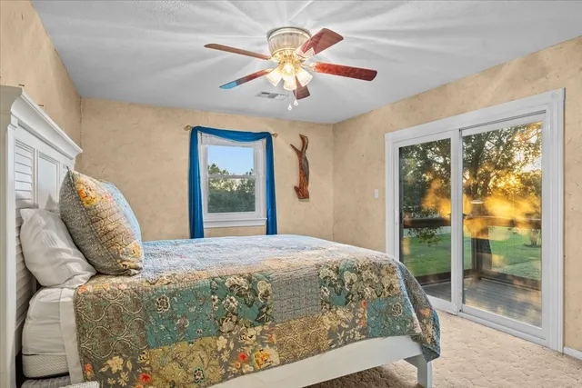 a bedroom with a bed chandelier and a window