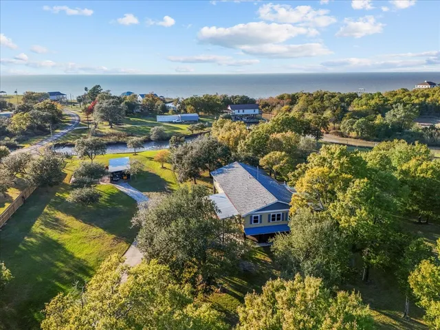 a view of a house next to a big yard with large trees