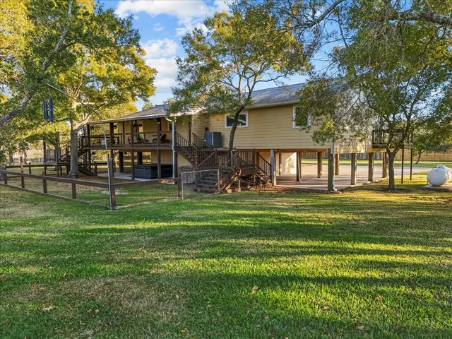 a front view of a house with a yard and a large tree
