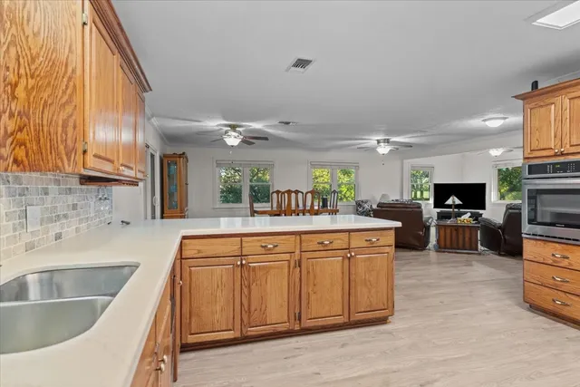 a kitchen with sink a microwave and cabinets