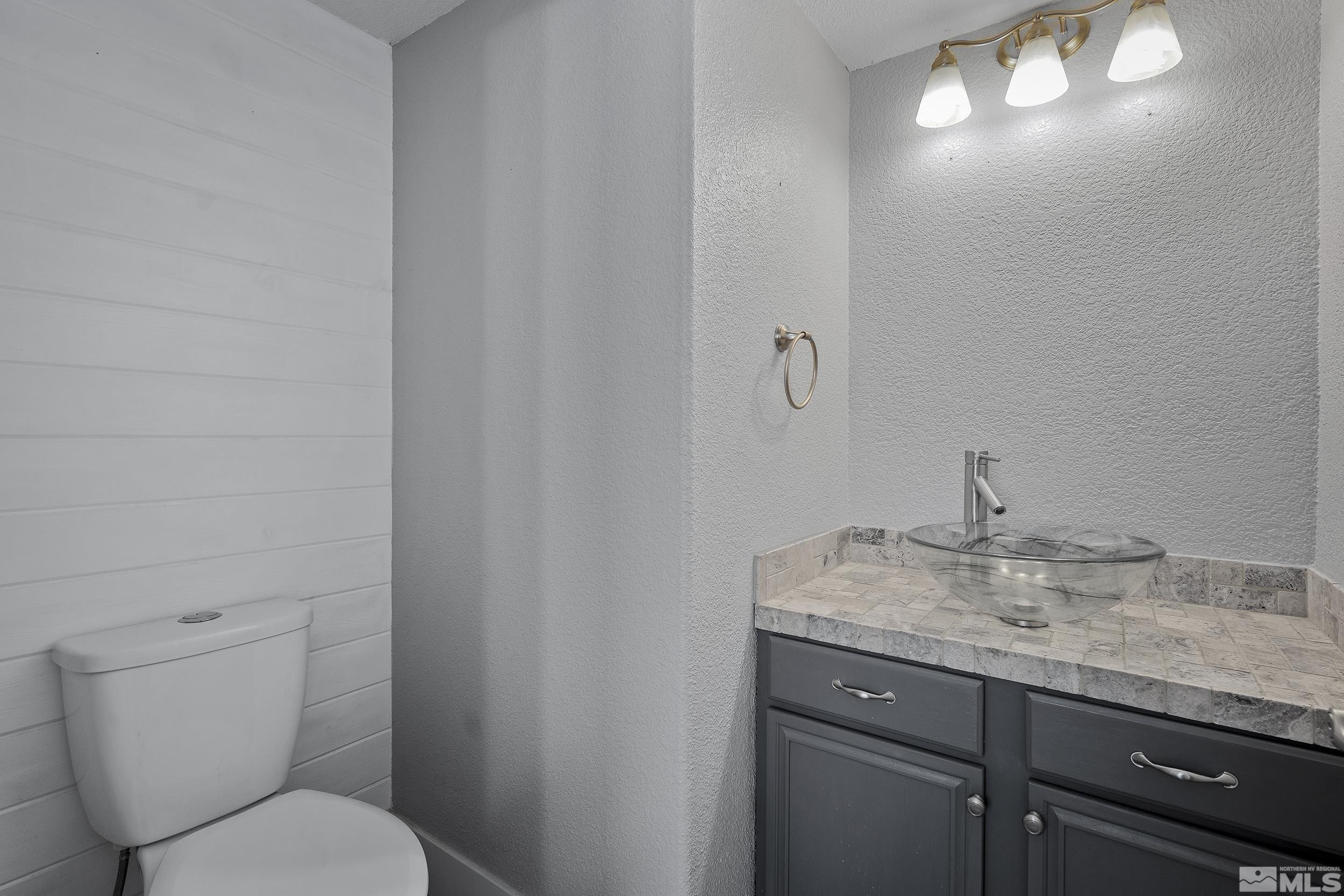 17940 Drift Creek Court Reno, NV 89508 - Photo 20 of 26 a bathroom with a granite countertop sink and a toilet