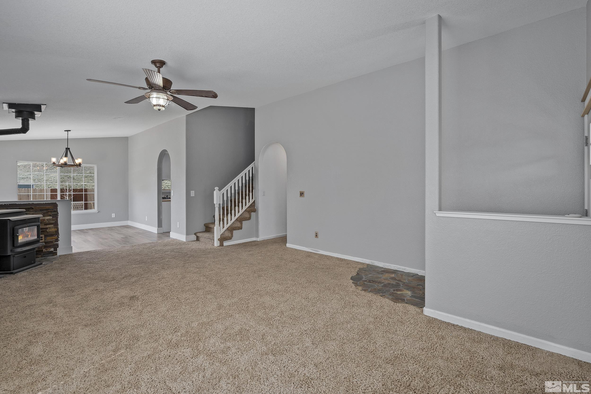 17940 Drift Creek Court Reno, NV 89508 - Photo 4 of 26 an empty room with fireplace chandelier fan and windows