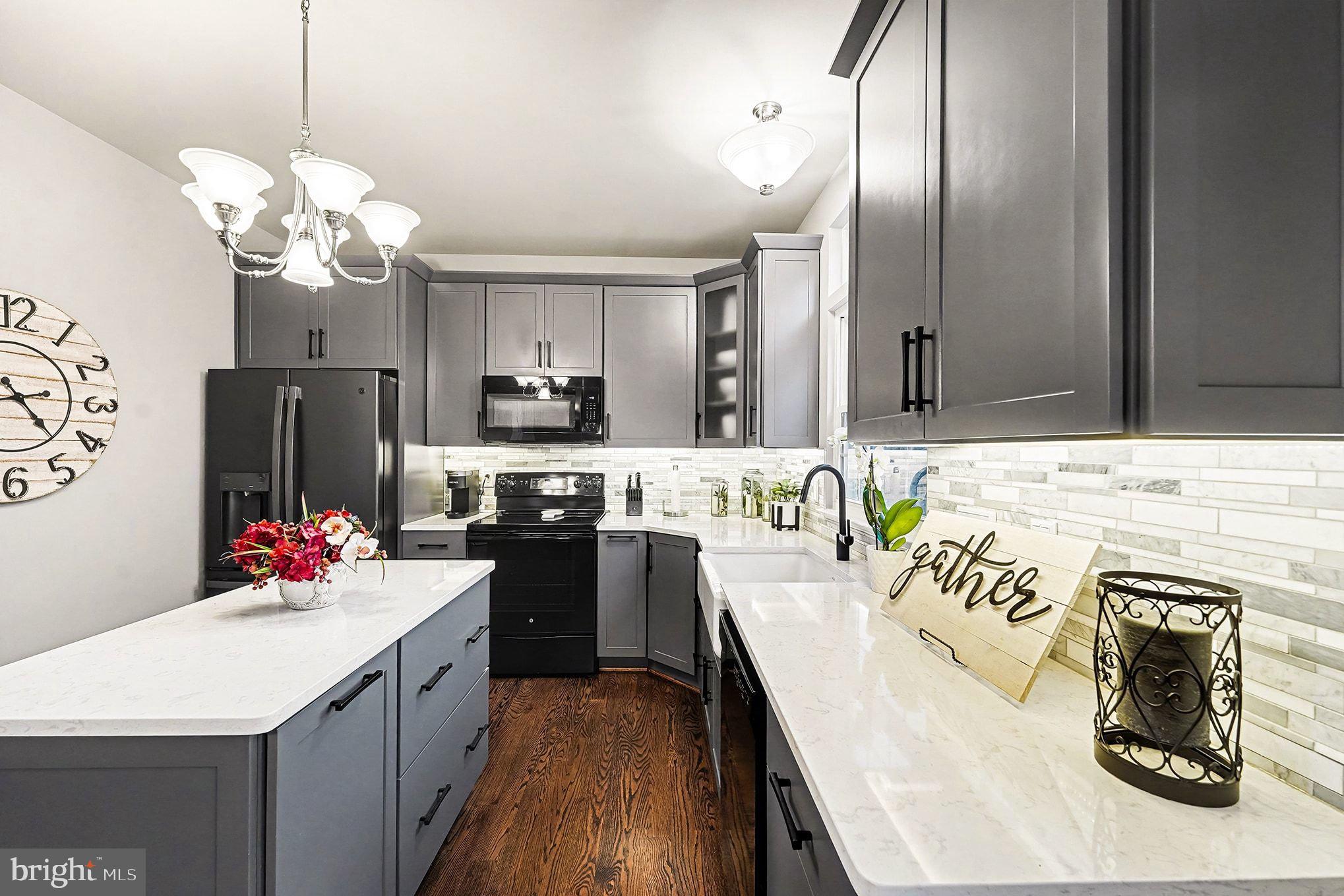6465 Colonial Village Loop Manassas, VA 20112 - Photo 13 of 39 a kitchen with stainless steel appliances kitchen island granite countertop a sink dishwasher a refrigerator and a dining table with wooden floor