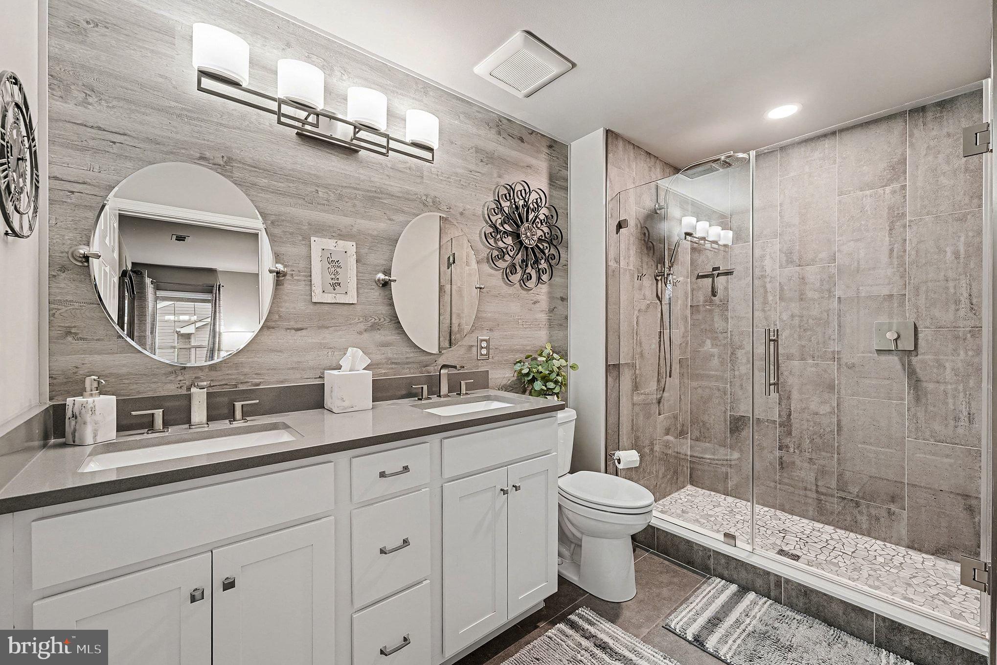 6465 Colonial Village Loop Manassas, VA 20112 - Photo 22 of 39 a bathroom with a double vanity sink toilet mirror and shower
