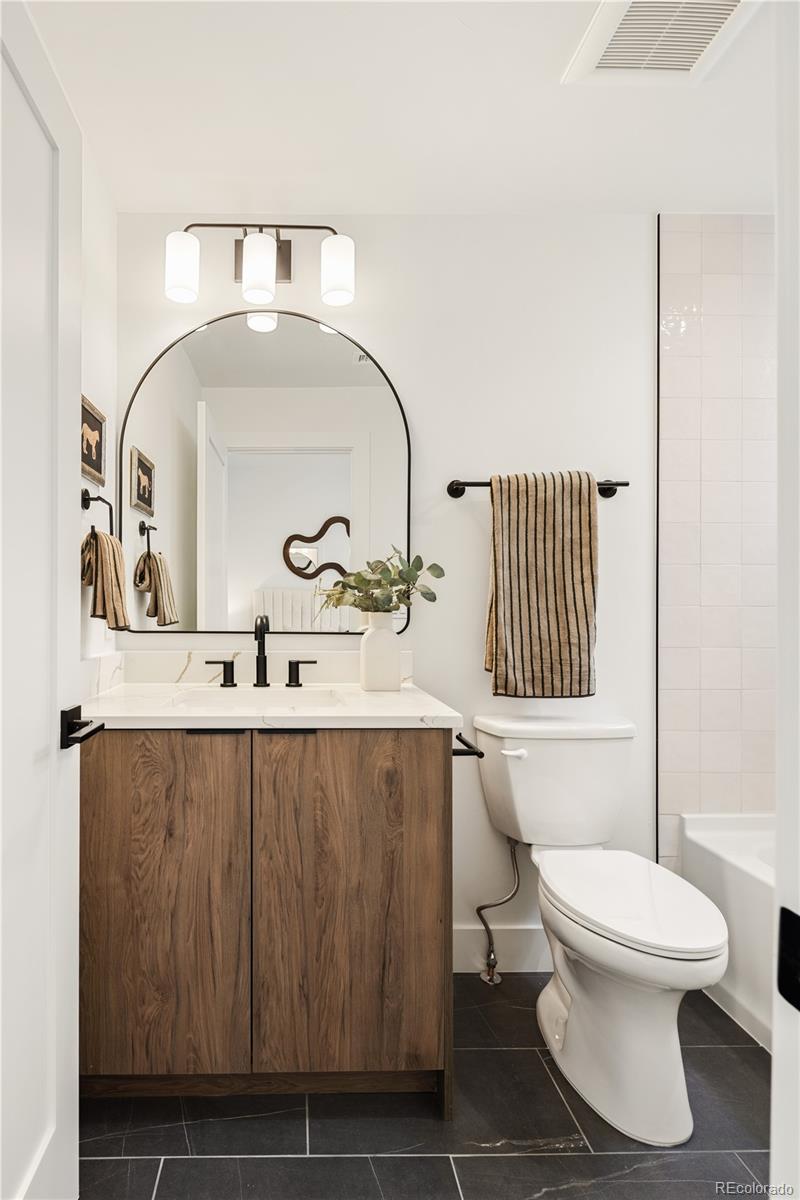 4511 Tennyson Street Denver, CO 80212 - Photo 24 of 34 a bathroom with a sink a toilet and a mirror