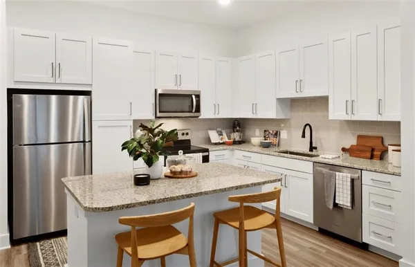 a kitchen with stainless steel appliances granite countertop a sink refrigerator and microwave