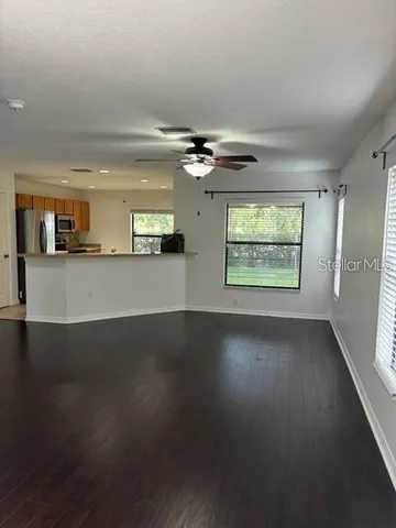 an empty room with windows and ceiling fan