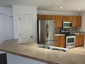 a kitchen with kitchen island granite countertop a stove a sink and a refrigerator