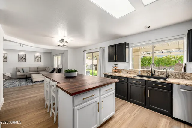 a kitchen with stainless steel appliances granite countertop sink stove microwave and cabinets