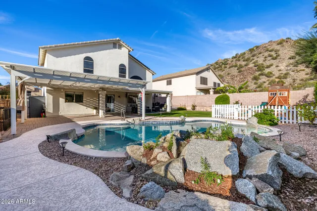 a view of a white house with a chairs in patio