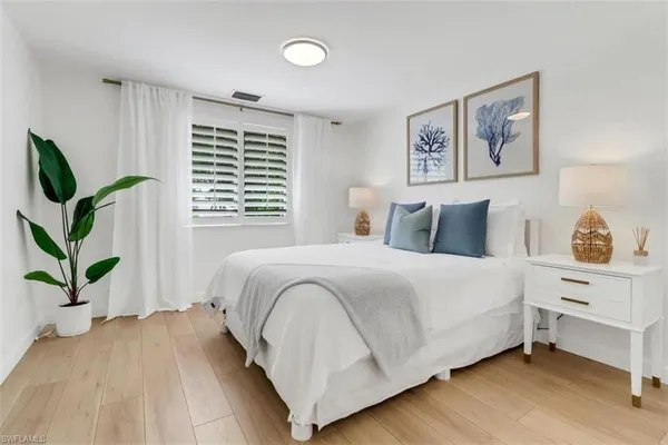 a bedroom with a bed and a potted plant