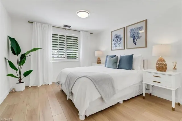 a bedroom with a bed and a potted plant