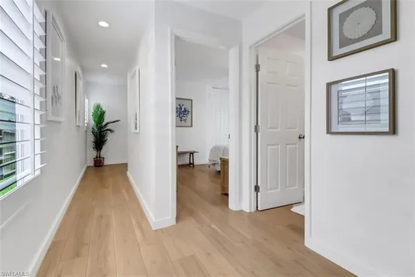 a view of a hallway with wooden floor and a living room