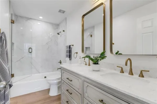 a bathroom with a sink a toilet and a large mirror