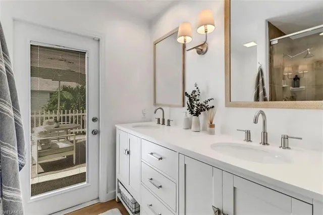 a bathroom with a double vanity sink mirror and next to a window