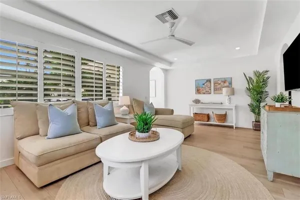 a living room with furniture kitchen view and a large window