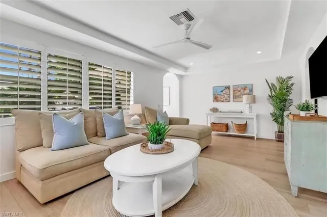 a living room with furniture kitchen view and a large window