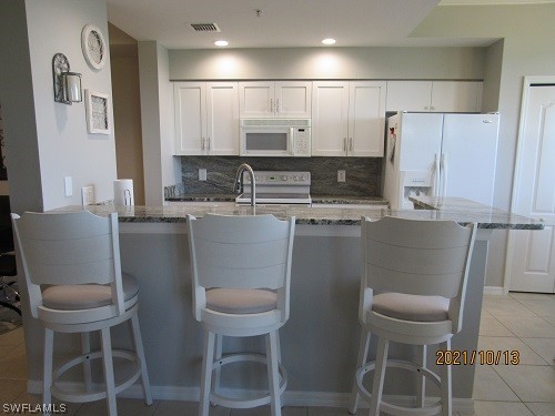a kitchen with a dining table chairs and a refrigerator