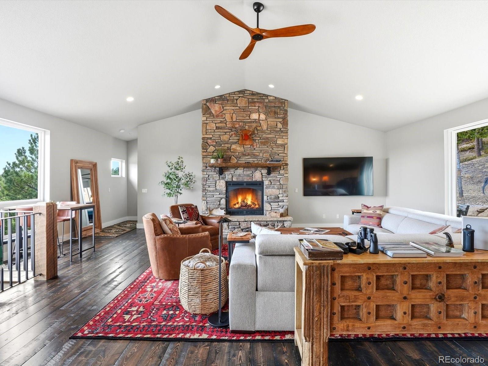 7333 Plowsher Way Morrison, CO 80465 - Photo 15 of 36 a living room with fireplace furniture and a flat screen tv